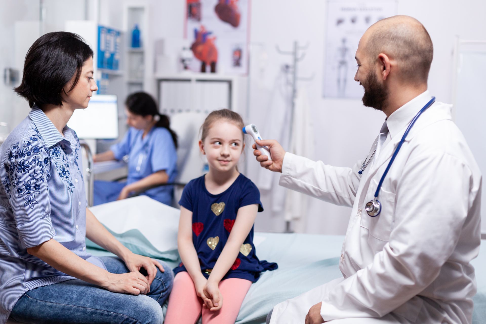 Doctor examining a child while a parent sits beside them in a clinic waiting area