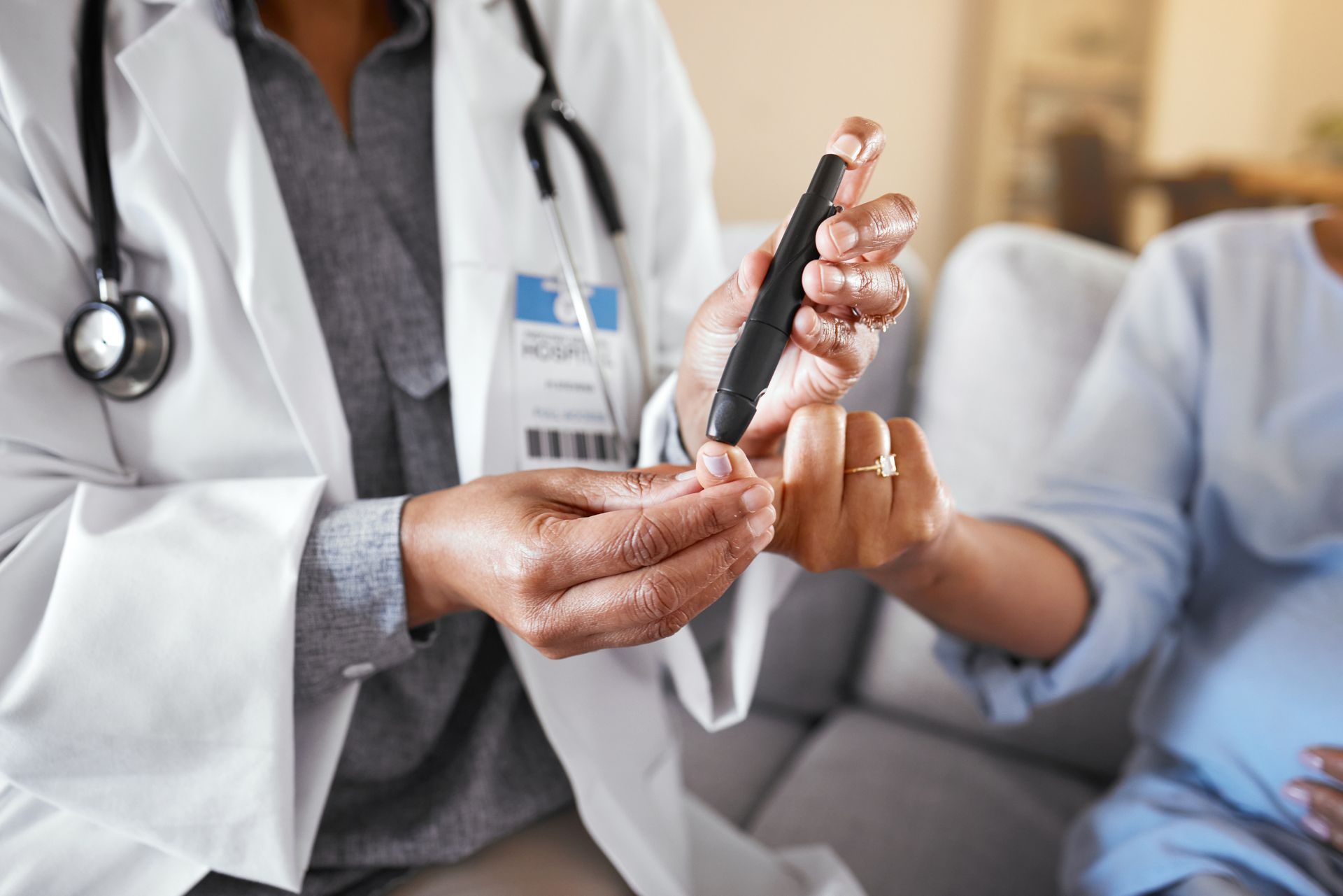 Doctor holding a pen and a patient’s hand in a clinic, suggesting a medical consultation