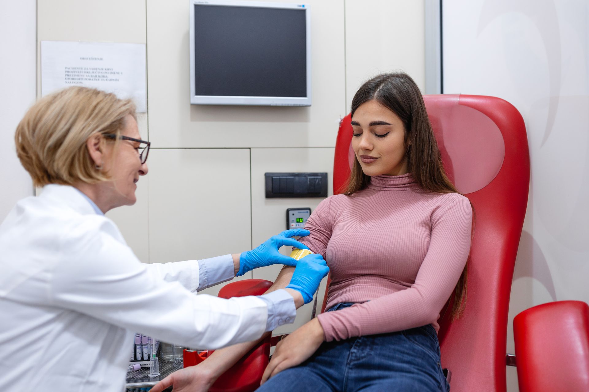 Doctor performing neck exam on patient lying on an examination table