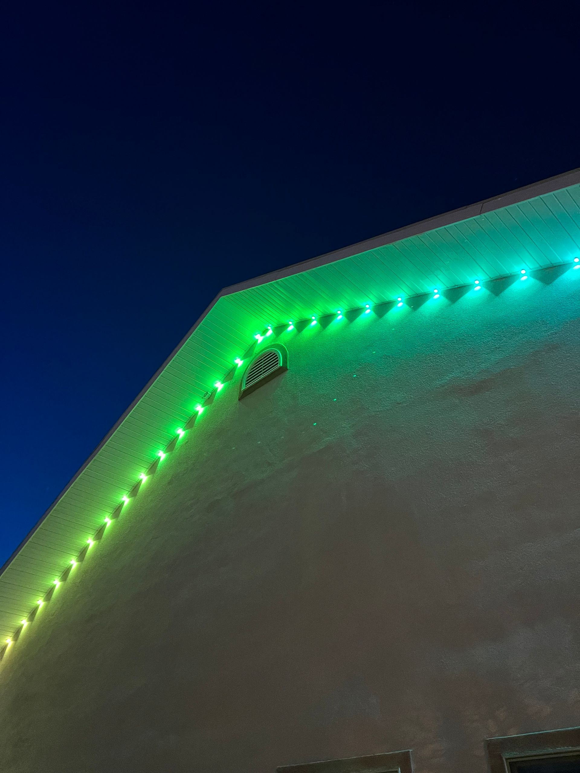 A green light illuminates the side of a building labeled