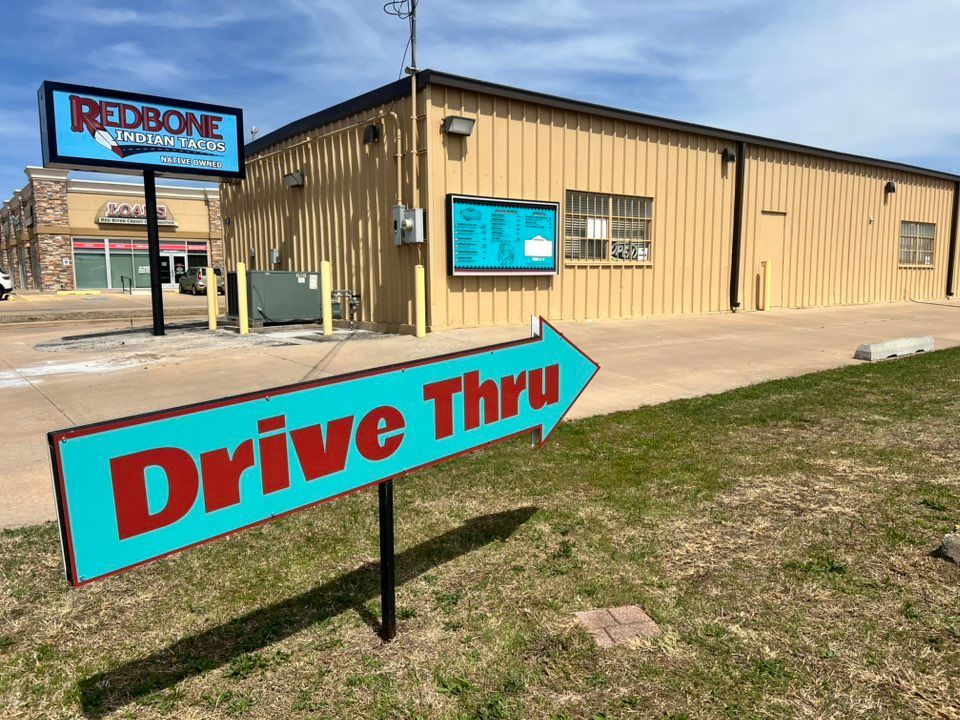 A drive thru sign is in front of a building.