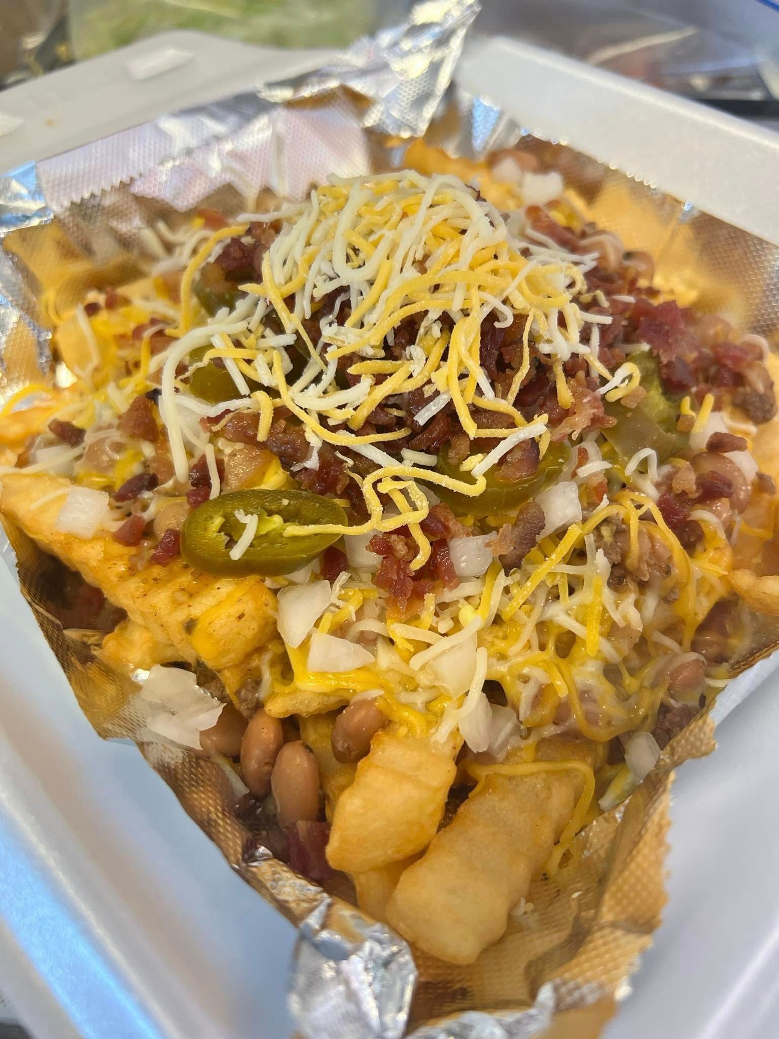 A basket of chicken wings and french fries on a checkered paper