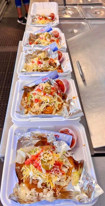 A row of styrofoam containers filled with food on a counter.