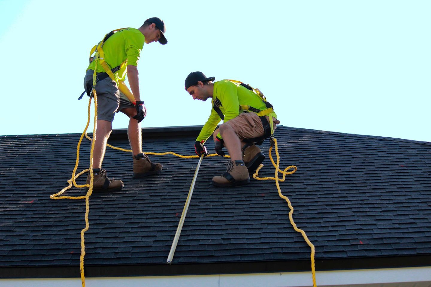 Two men are working on the roof of a house.