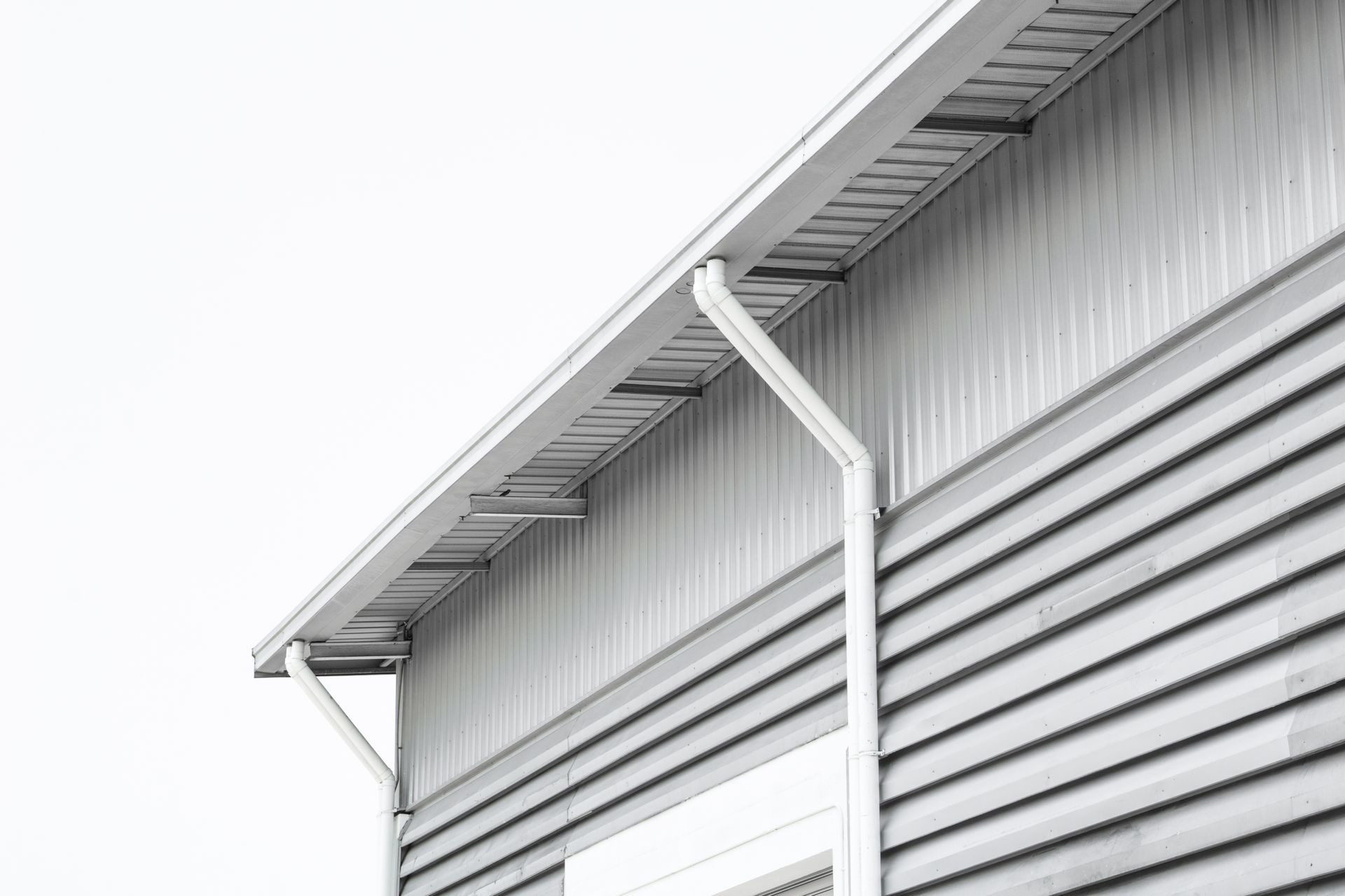 Gray building exterior with a white gutter system.