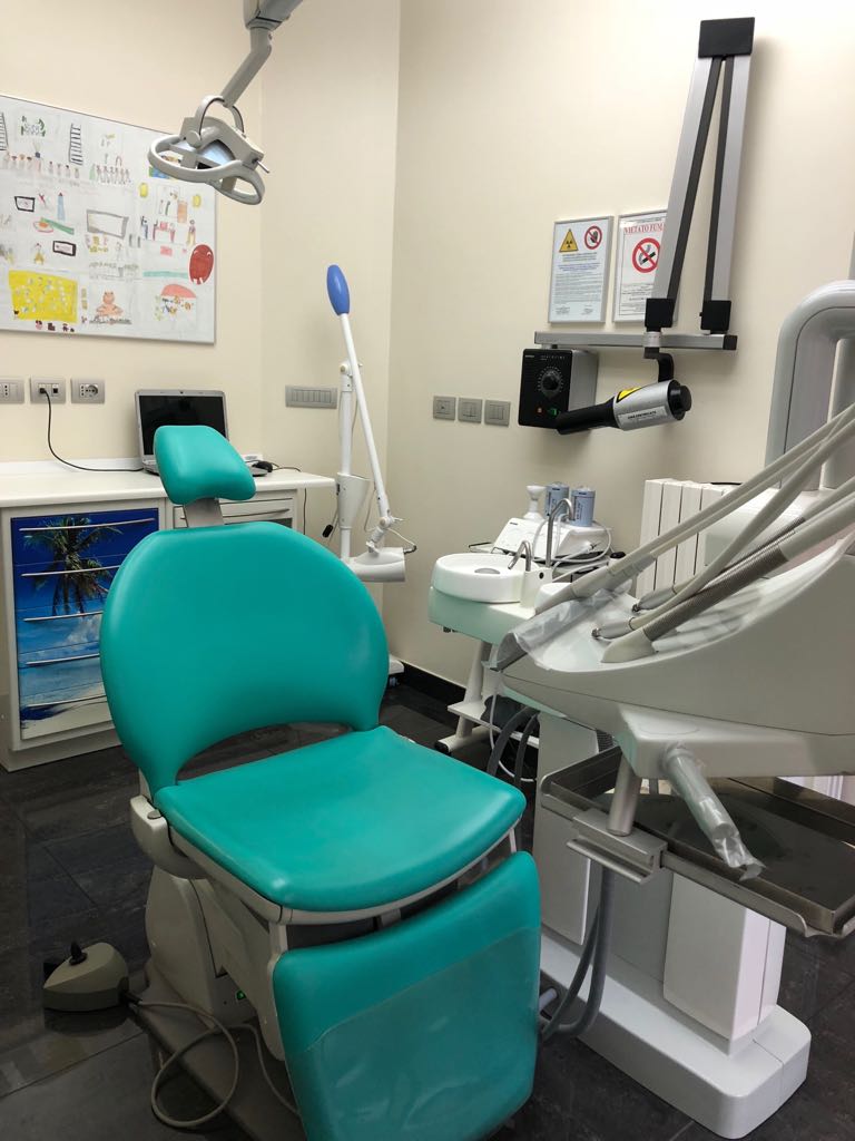 Una poltrona odontoiatrica verde in uno studio dentistico