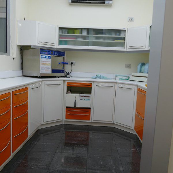 Una cucina con mobili bianchi e cassetti arancioni