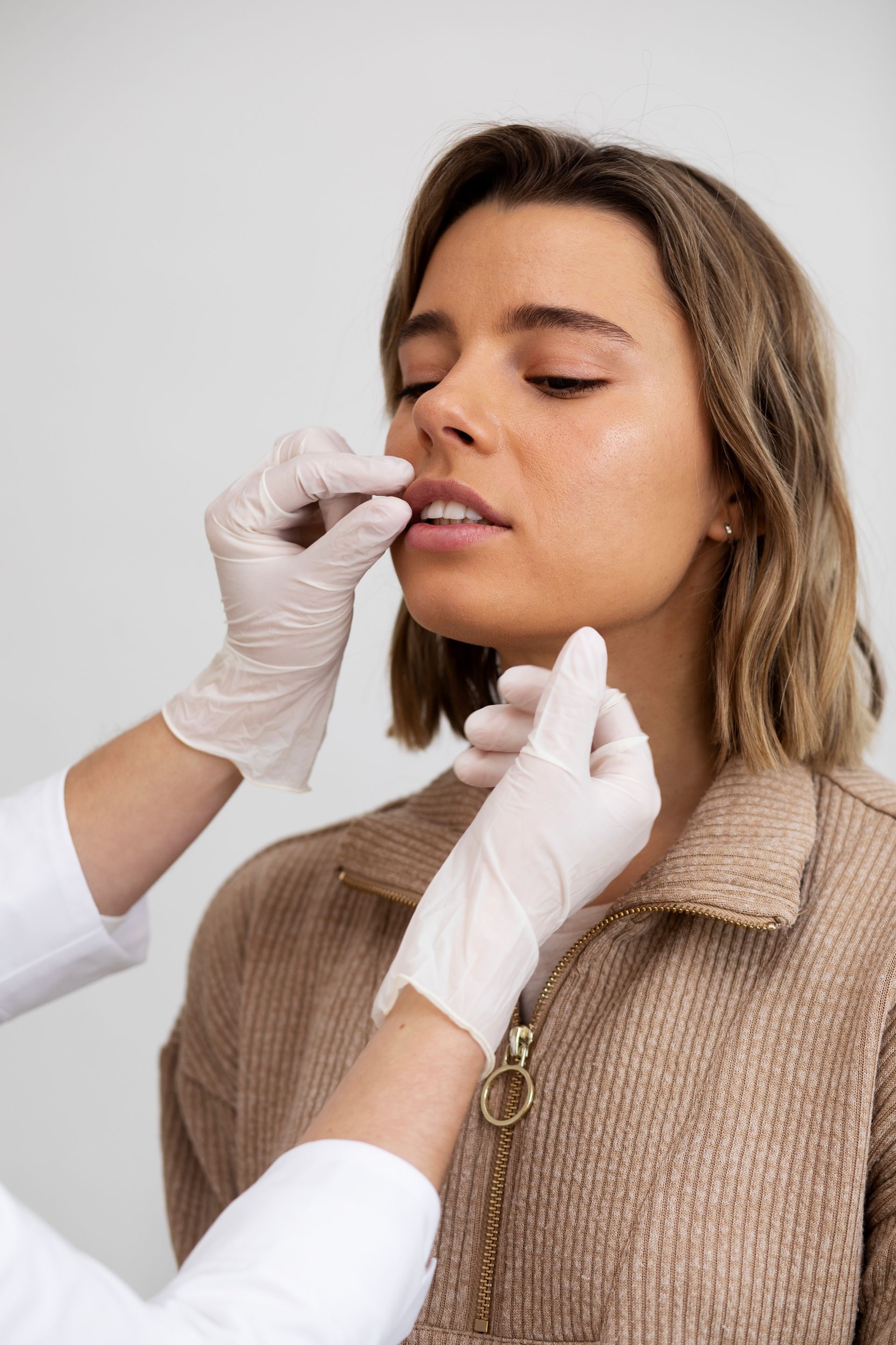 A woman is getting a botox injection in her lip.