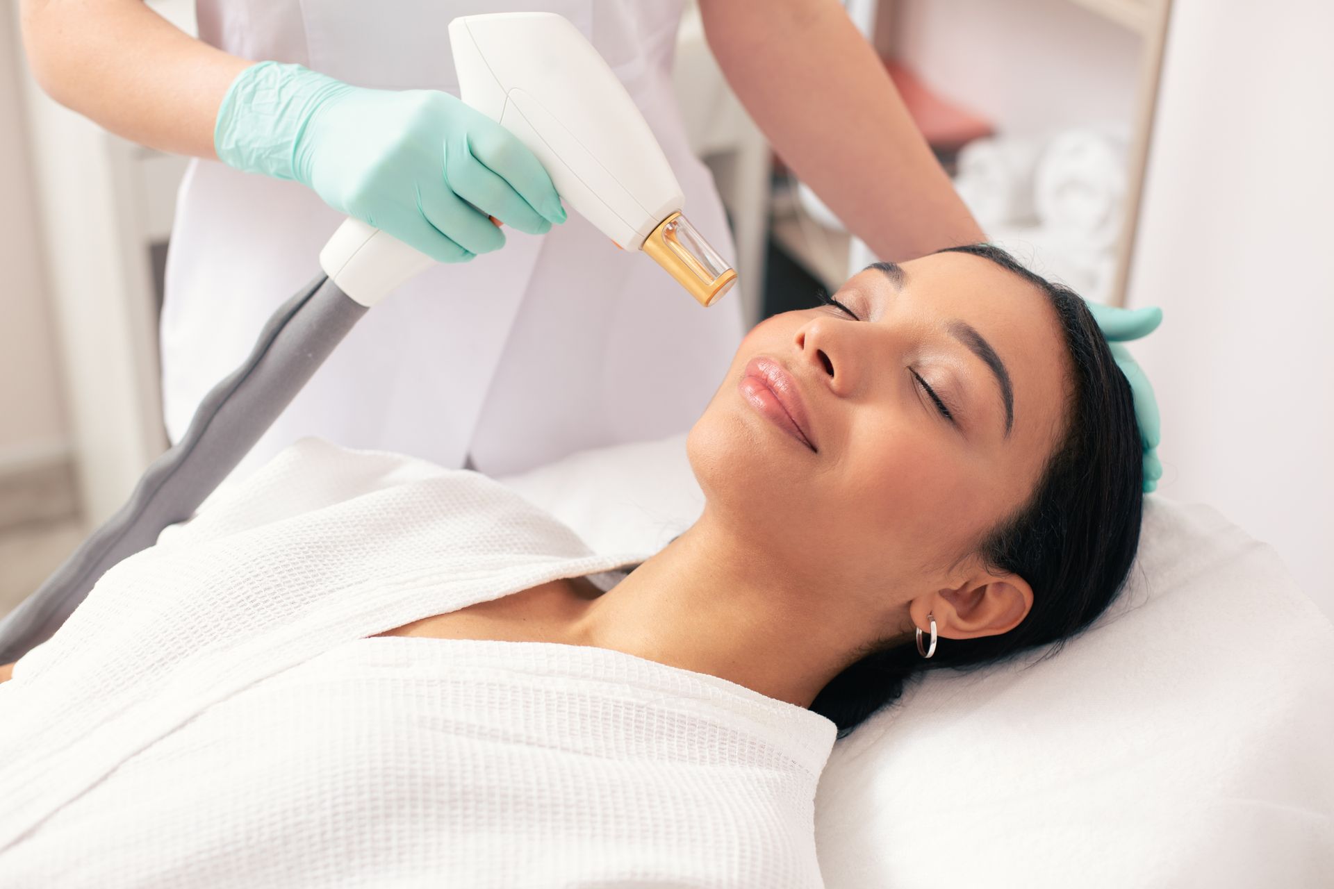 A woman is getting a laser treatment on her face.