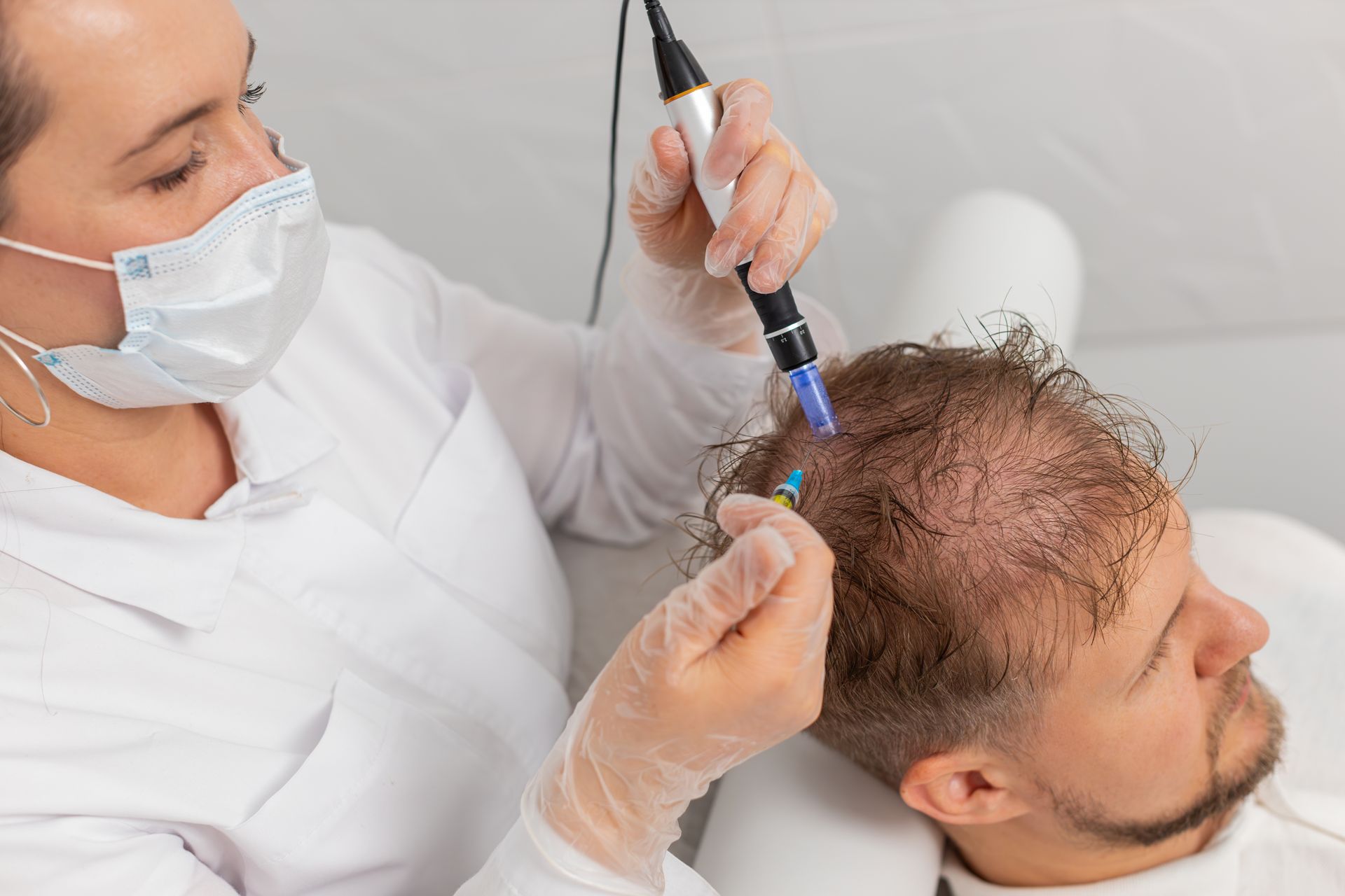 A person is getting a hair treatment with a pen.