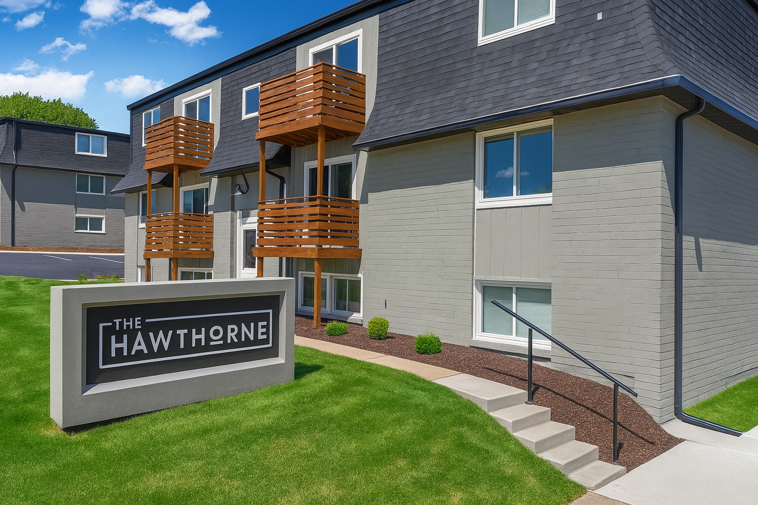 A large brick apartment building with a sign in front of it.