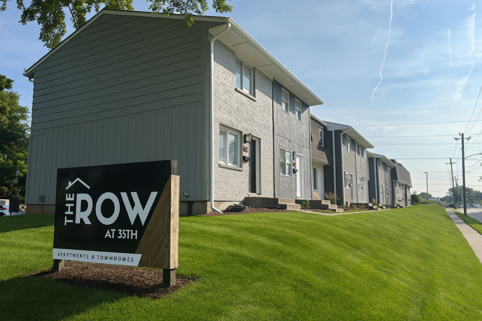 A row of apartment buildings with a sign in front of them.