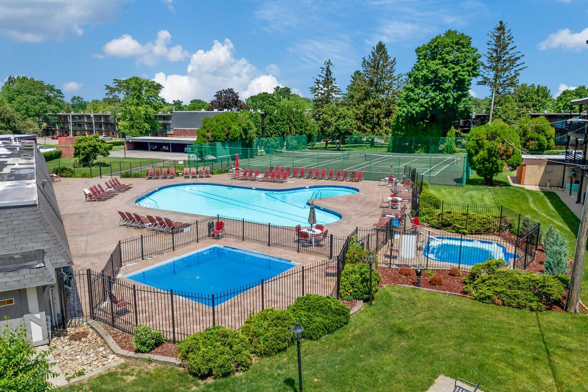 An aerial view of a large swimming pool surrounded by a fence.