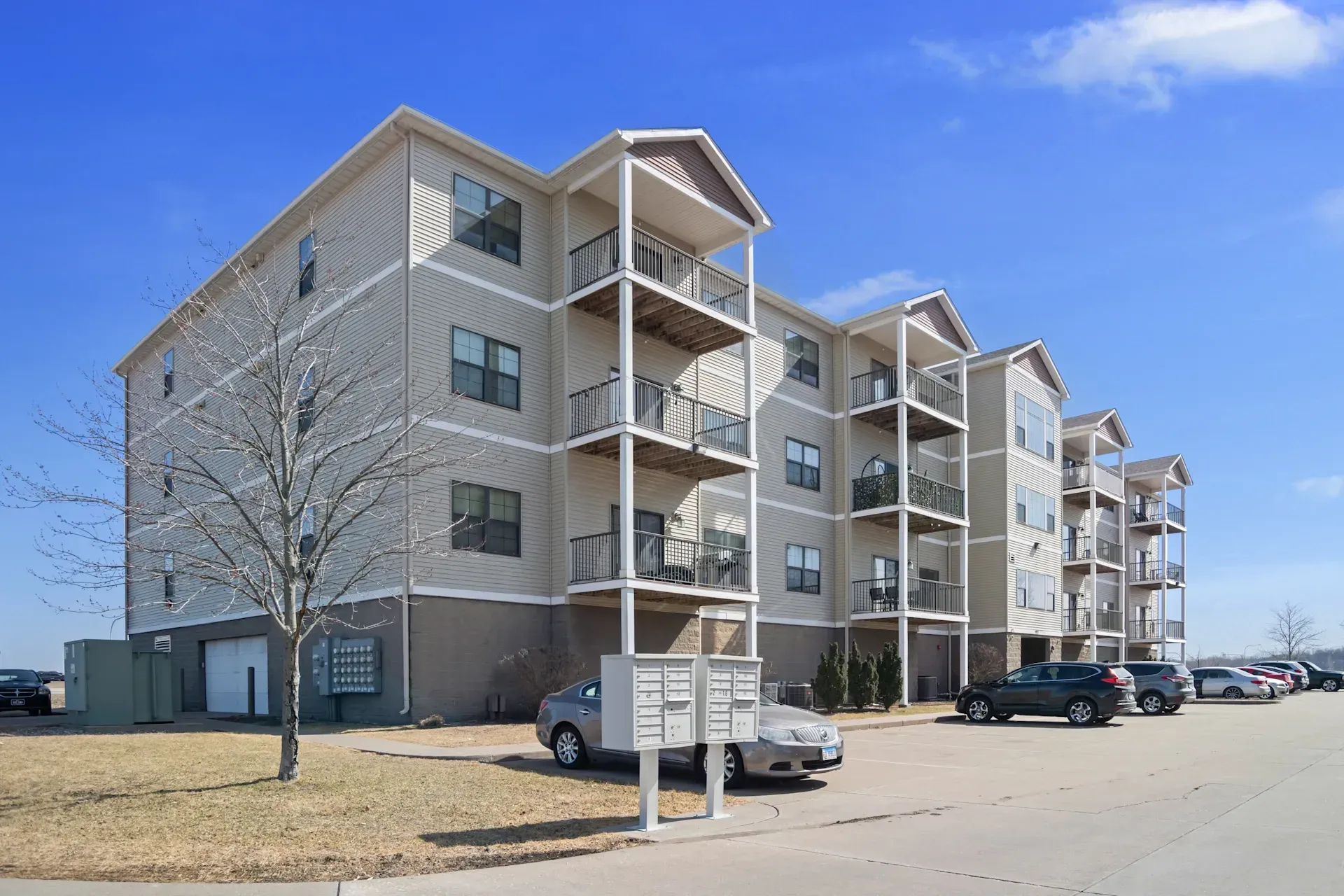 A large apartment building with cars parked in front of it.