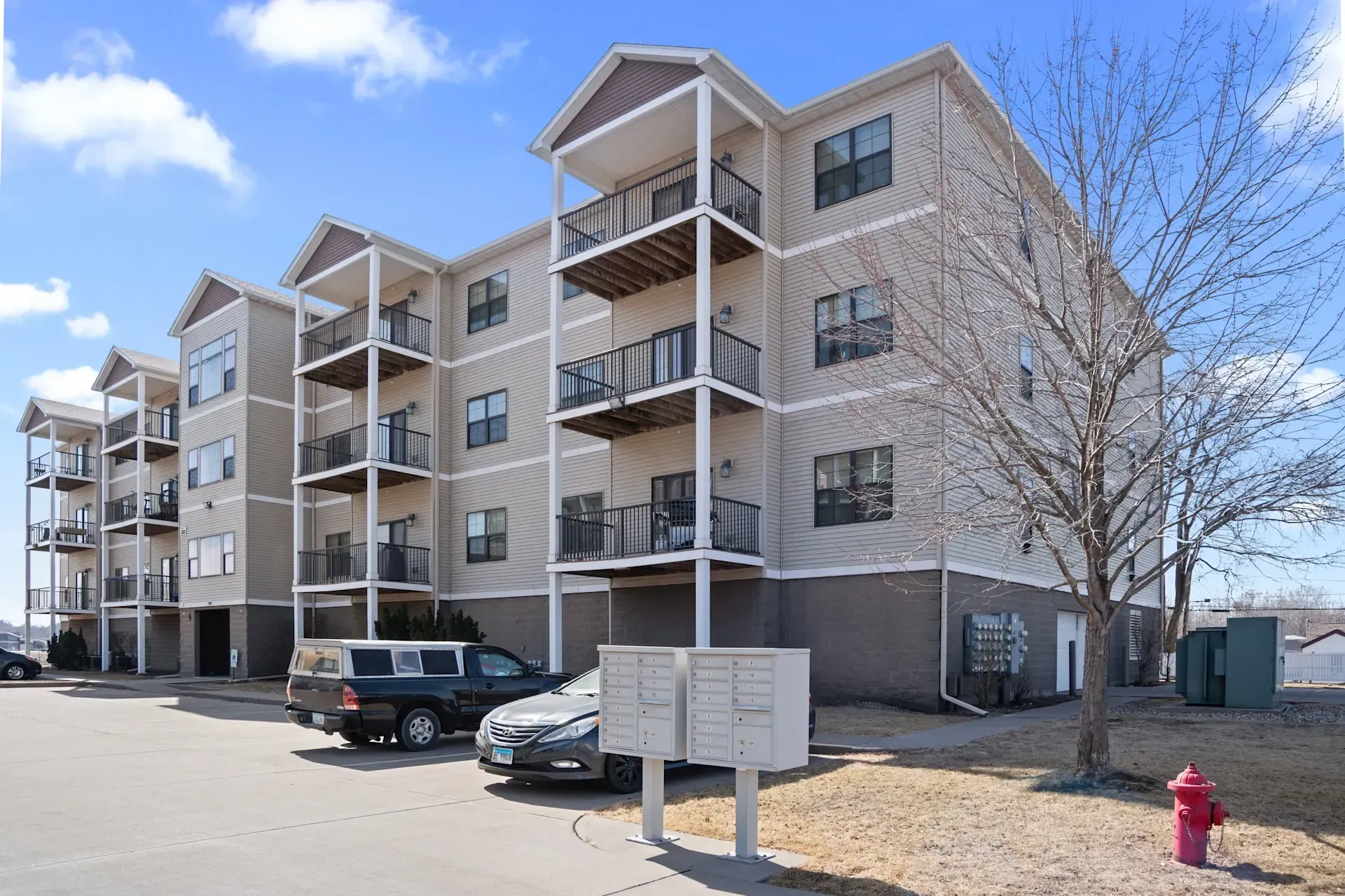 A large apartment building with cars parked in front of it.