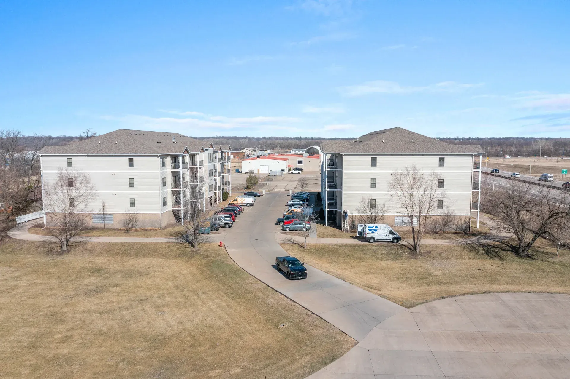 An aerial view of a apartment complex with cars parked in front of it.