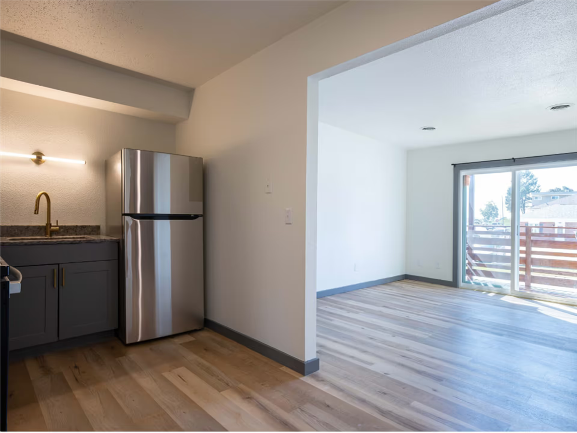 A kitchen with a stainless steel refrigerator and a sink
