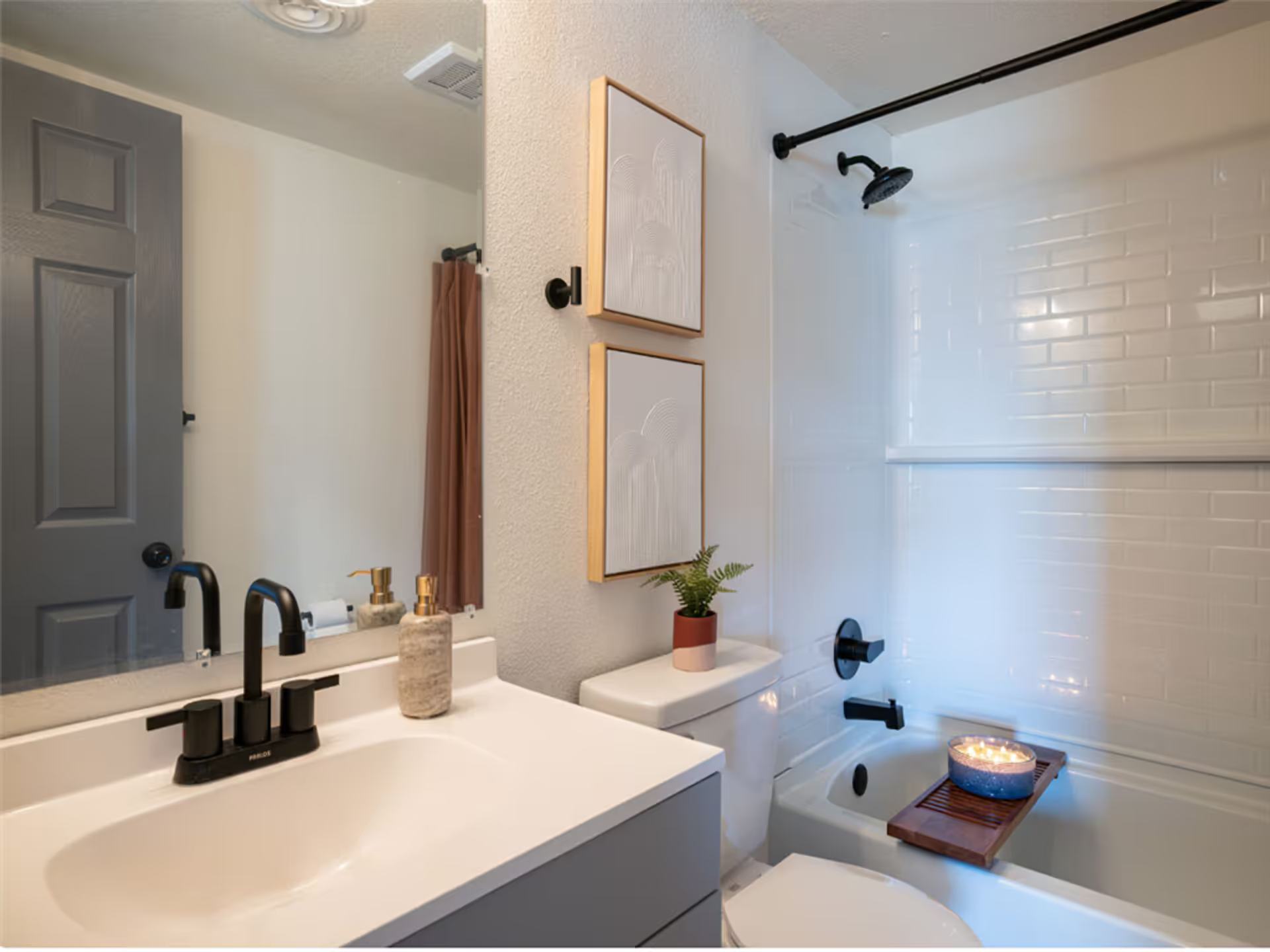 A bathroom with a sink , toilet , tub and shower.