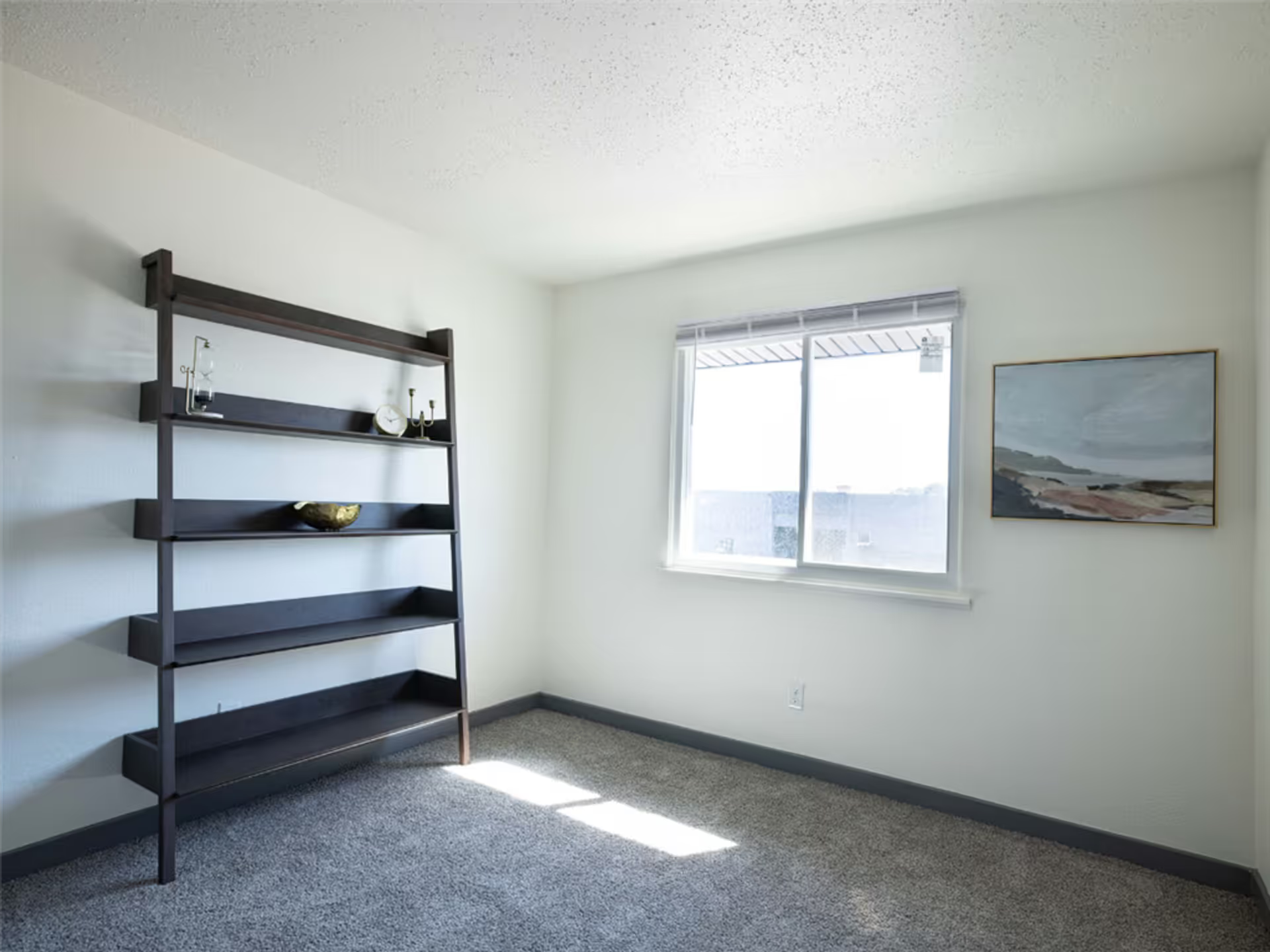An empty room with a bookshelf and a window