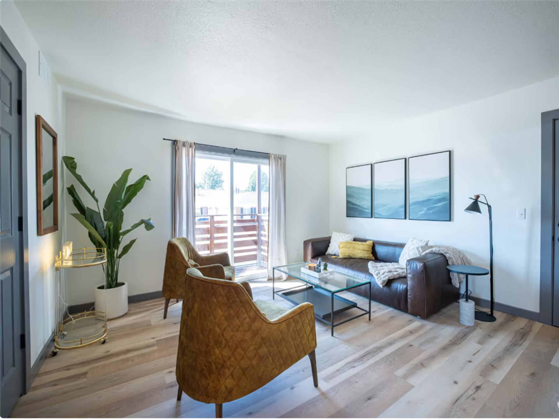 A living room with a couch and two chairs