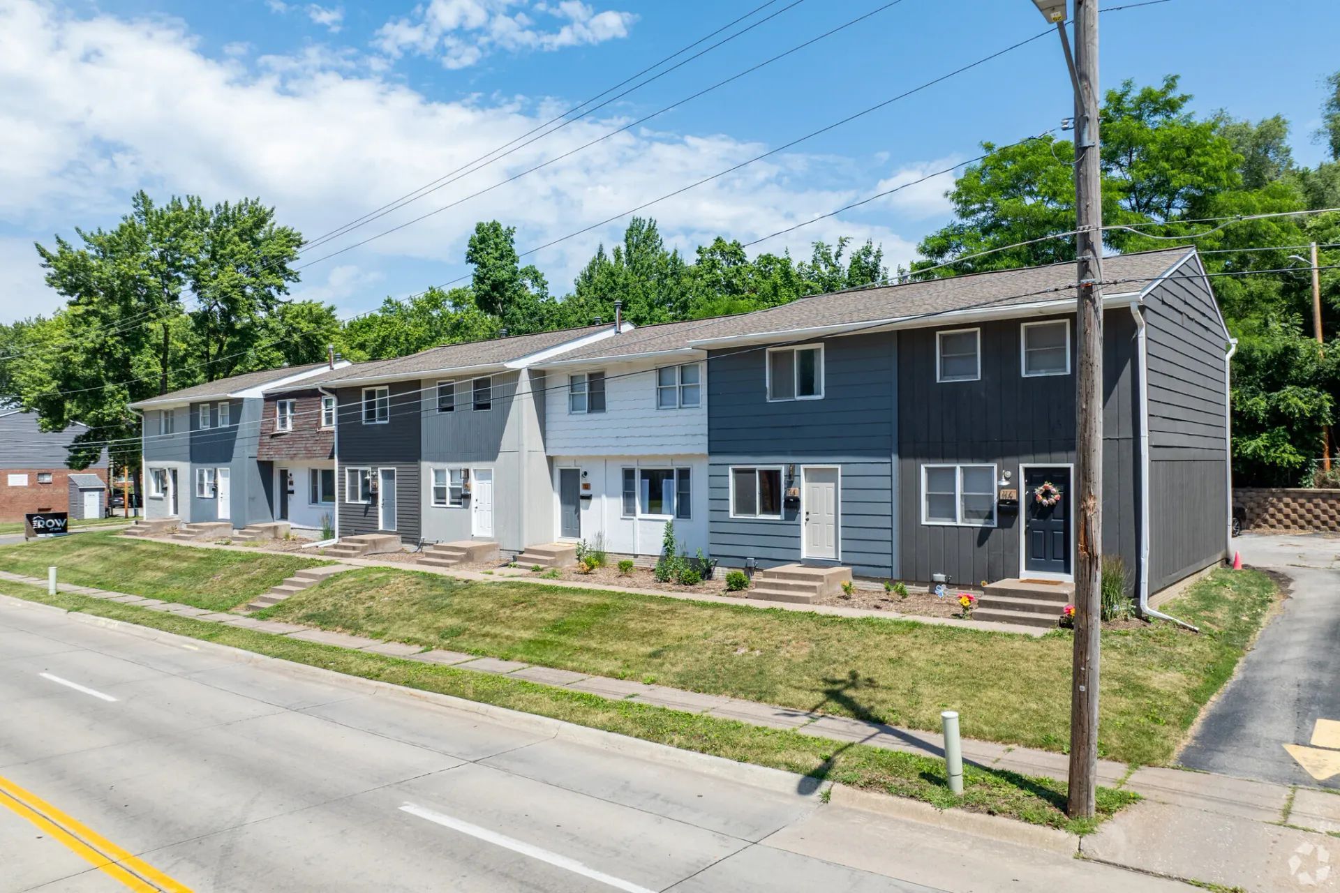 A row of houses sitting next to each other on the side of a road.