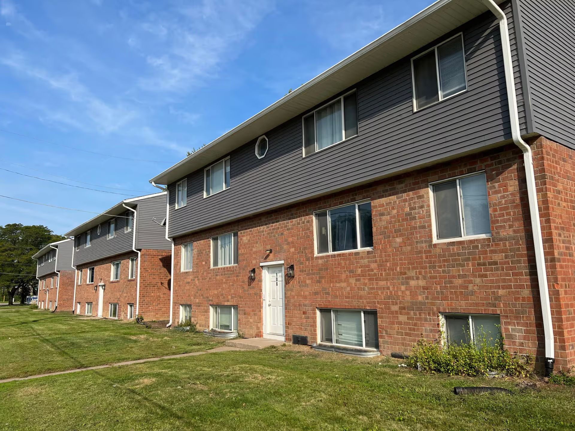 A row of brick apartment buildings with a lot of windows on a sunny day.