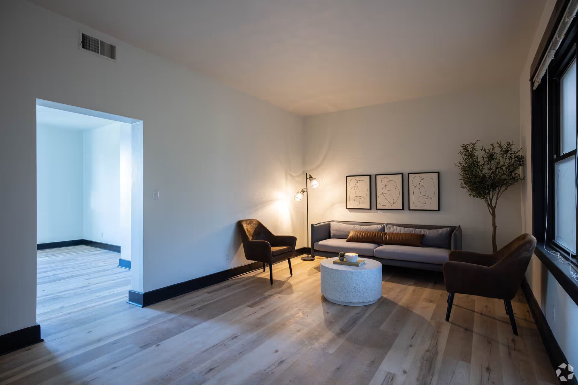 A living room with a couch , chairs , and a coffee table.