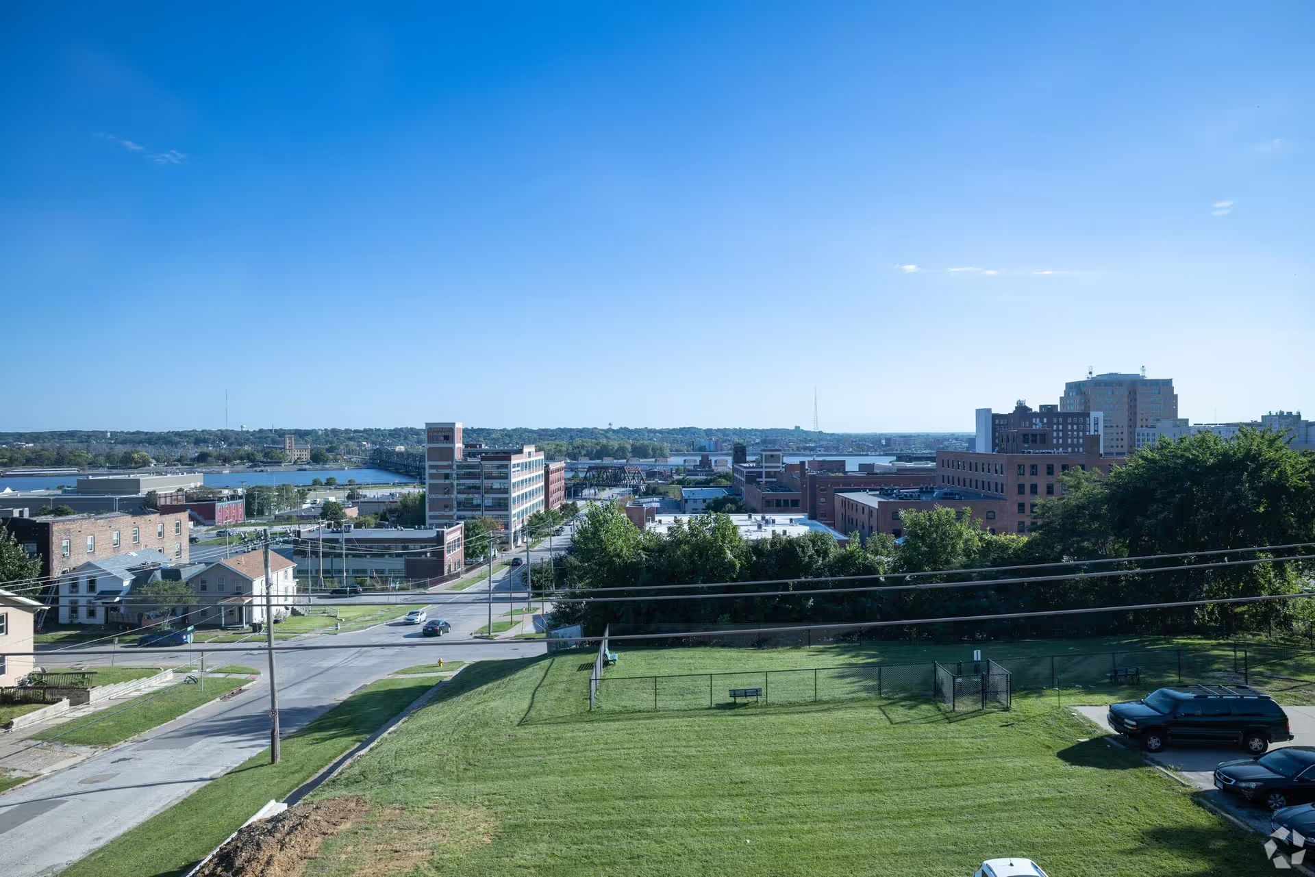 An aerial view of a city with a lot of cars parked on the side of the road.