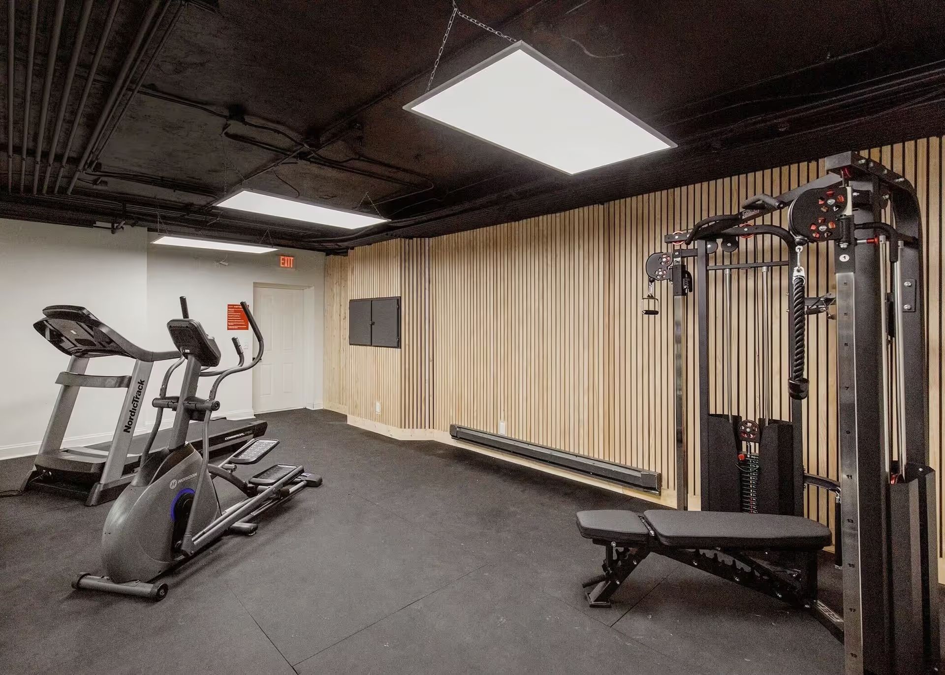 A gym with treadmills , exercise bikes , and a bench.