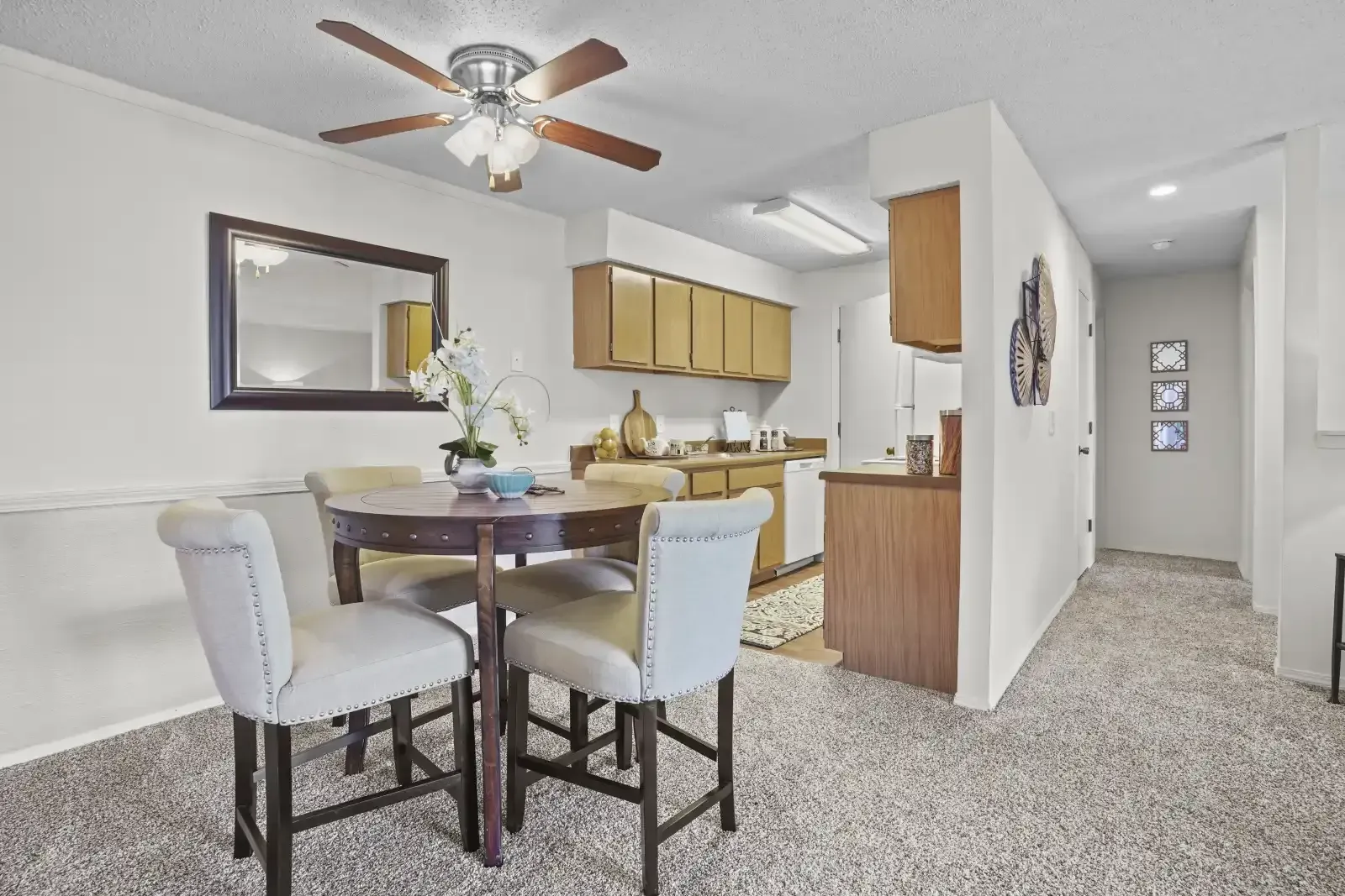 Cozy dining area with a round table and four chairs in an apartment kitchen.