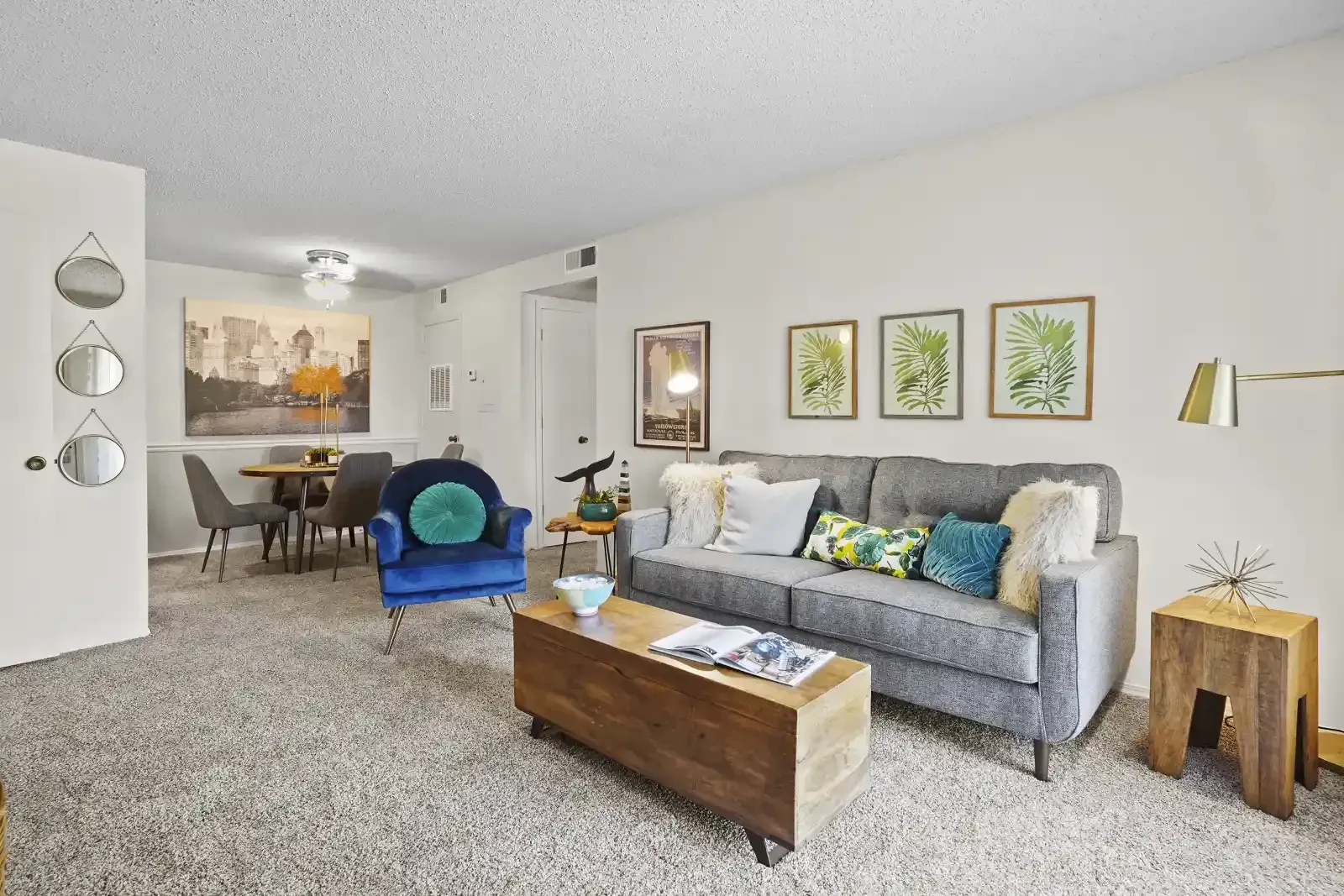 Cozy living room featuring a grey sofa, blue accent chair, and a wooden coffee table.