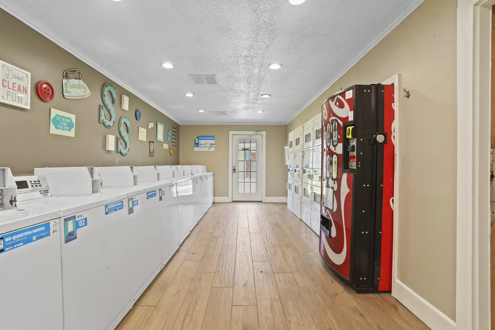 Indoor laundry room with vending machine and decorative wall.