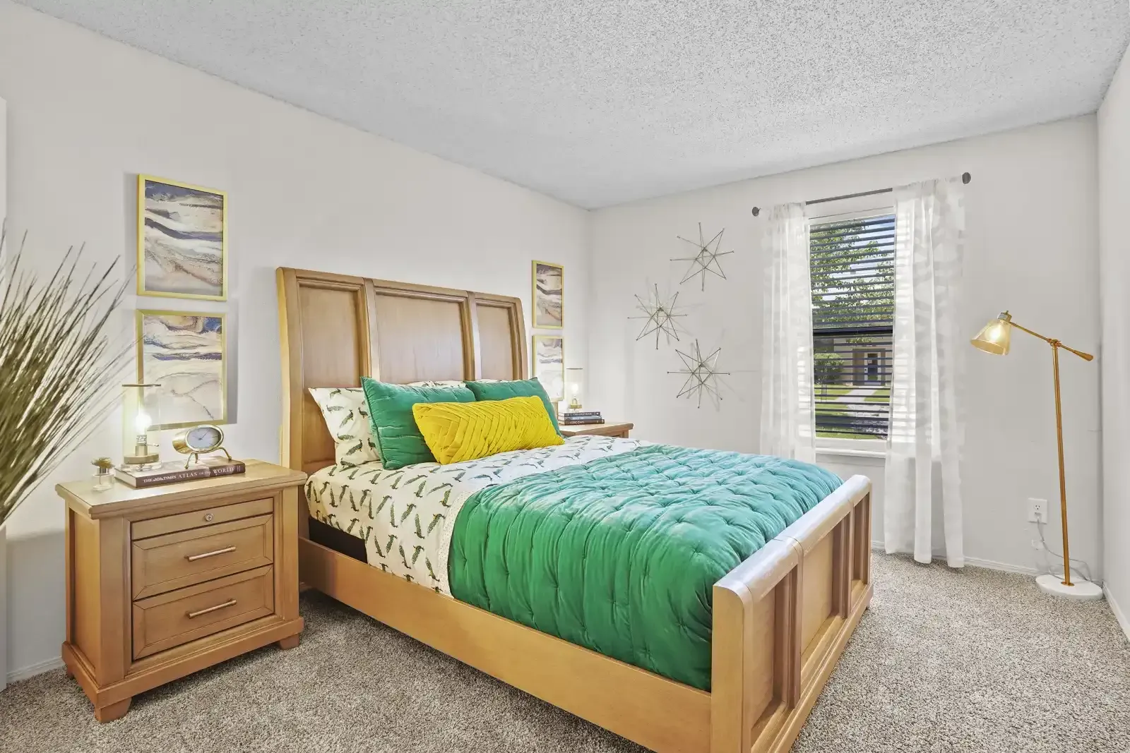 Cozy bedroom with a green quilt, wooden furniture, and decorative wall art