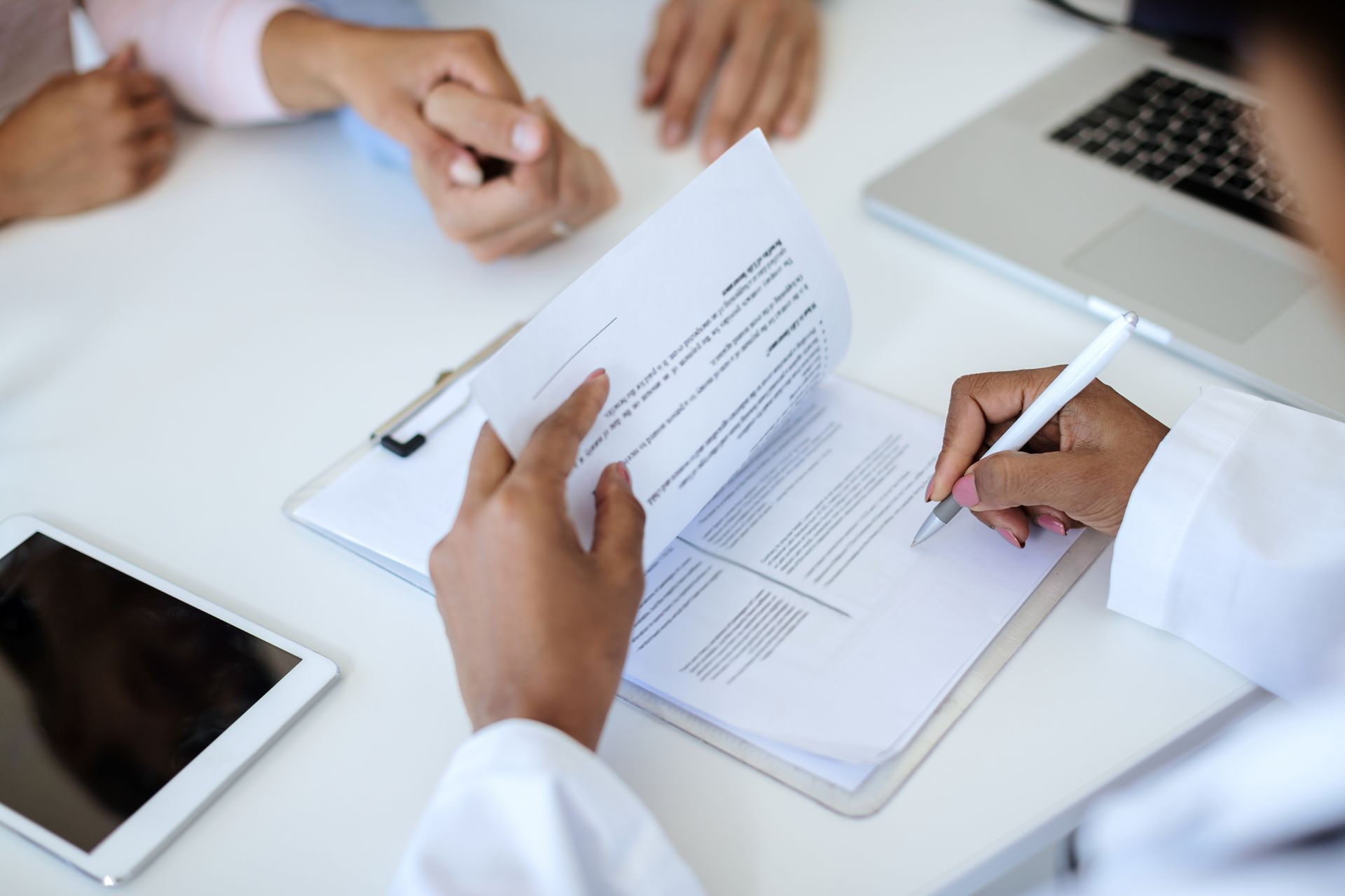 A doctor is signing a document in front of a group of people.