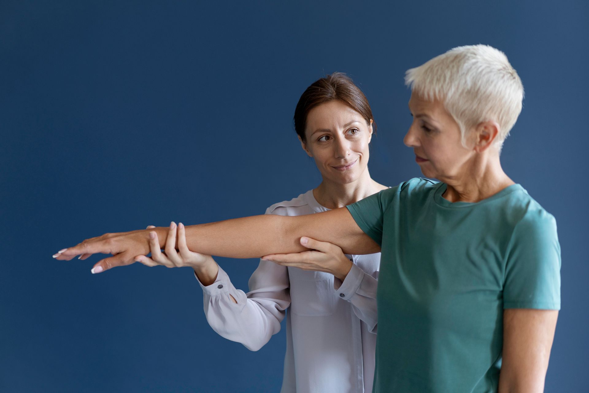 A woman is examining another woman 's arm.