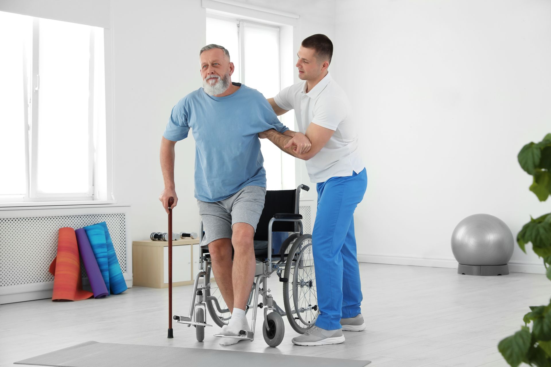 A man in a wheelchair is being helped by a nurse.