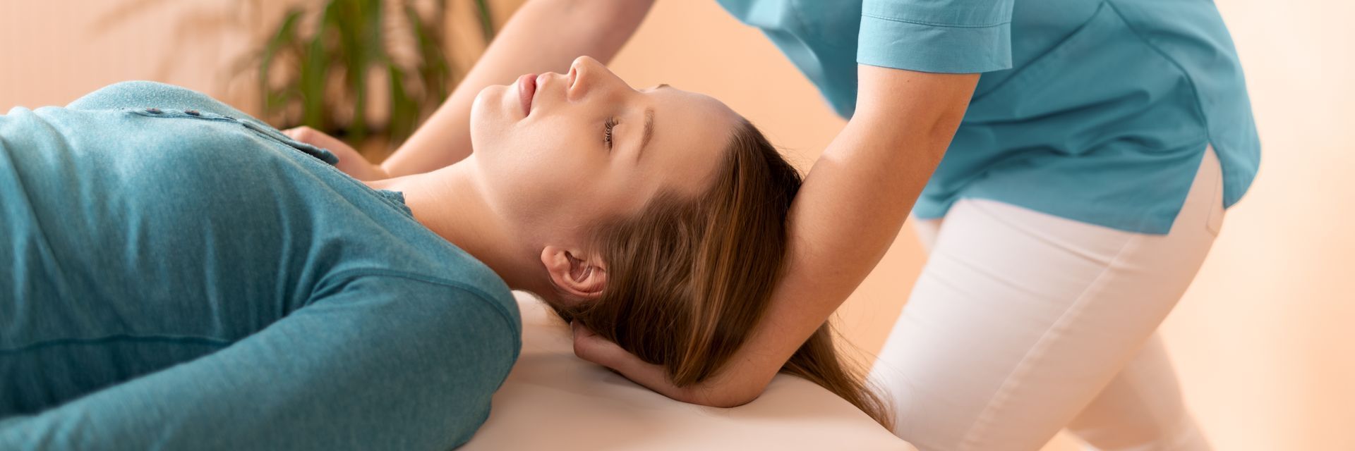 A woman is laying on a table getting a massage.