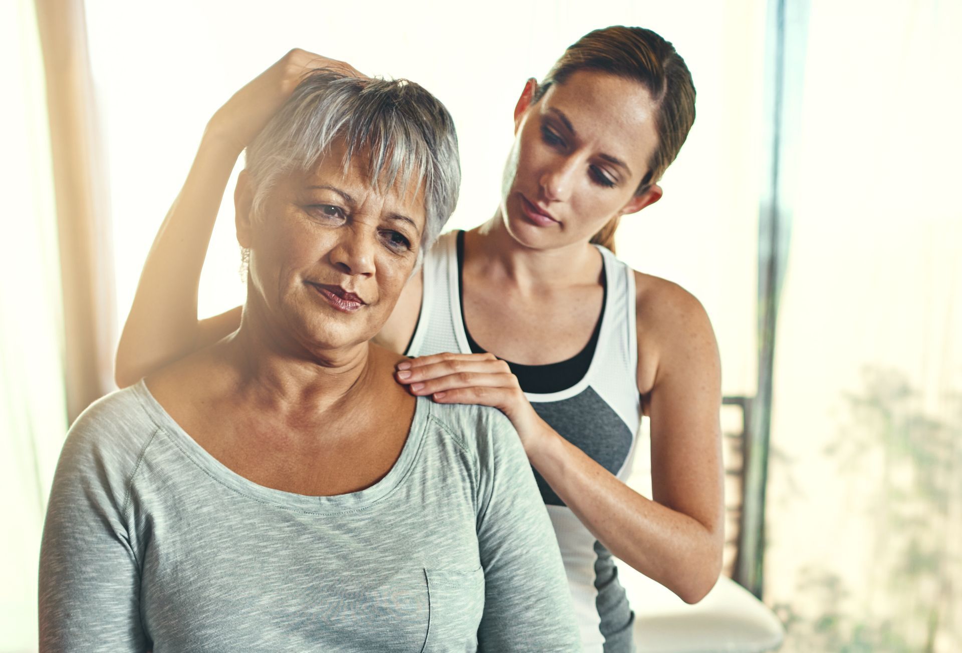 An older woman is getting a massage from a younger woman.