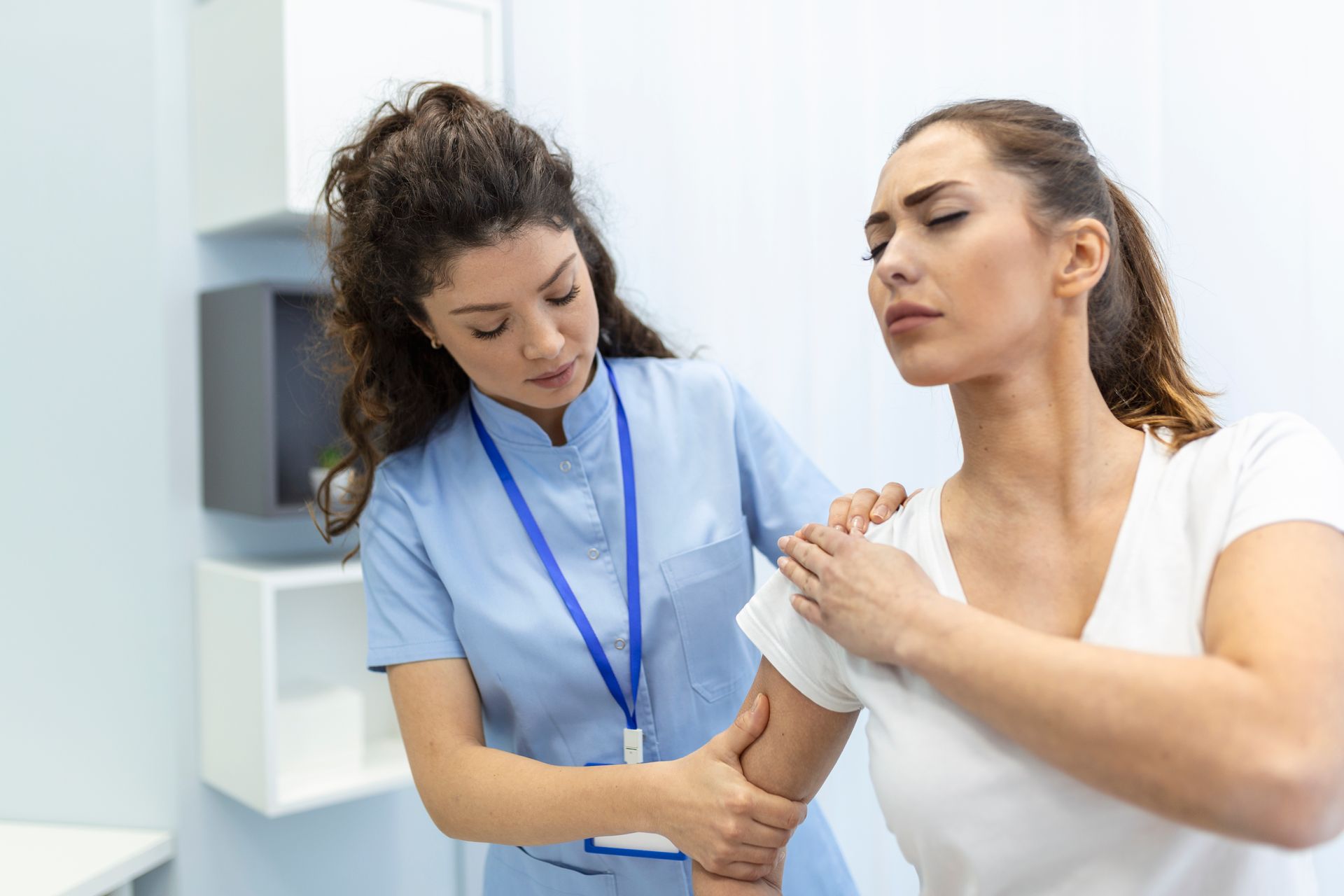 A nurse is examining a patient 's arm in a hospital.