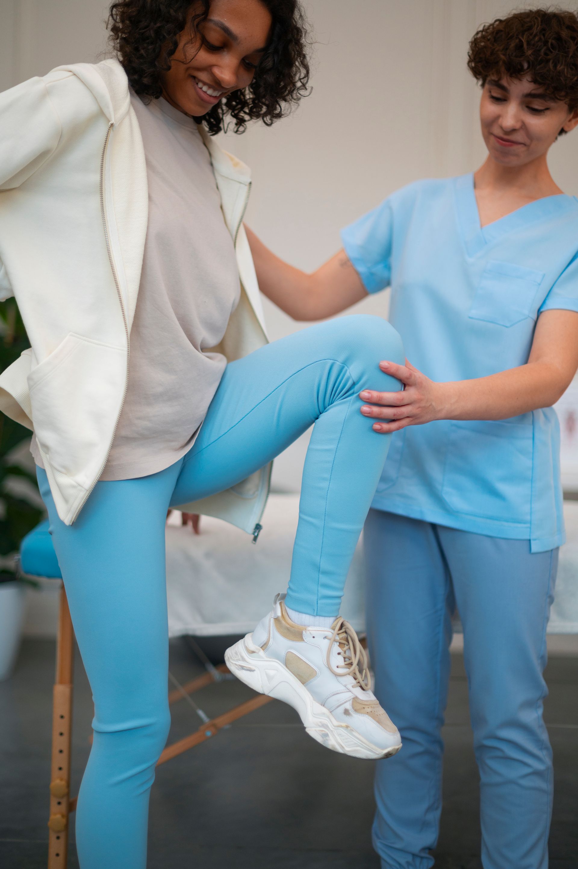 A nurse is helping a woman stretch her leg.