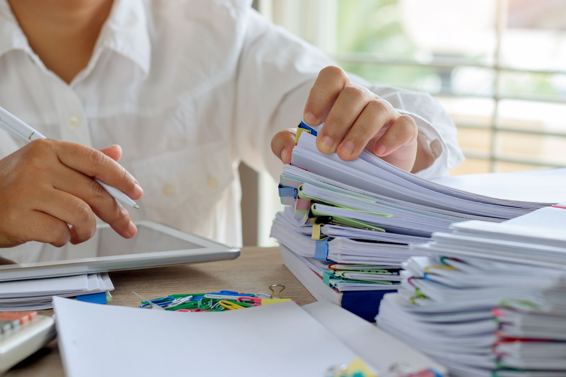 Teacher grading exam papers at desk with QME Test Prep materials. Teacher grading exam papers at desk with QME Test Prep materials.