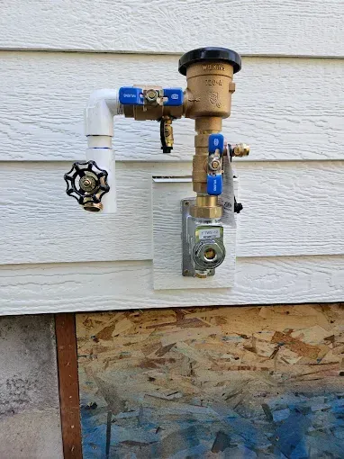 A close up of a faucet on the side of a house.