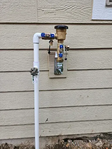 A water pipe is attached to the side of a house.