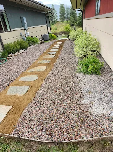 A stone walkway is being built in front of a house.
