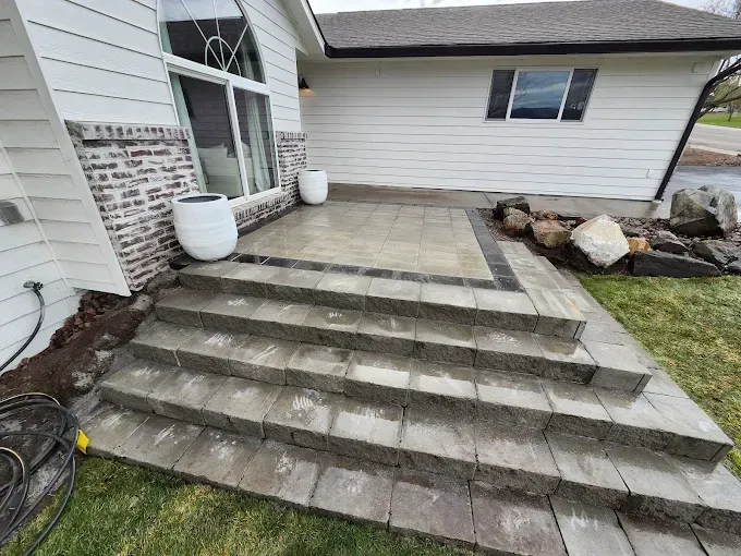 A house with a patio and stairs in front of it.