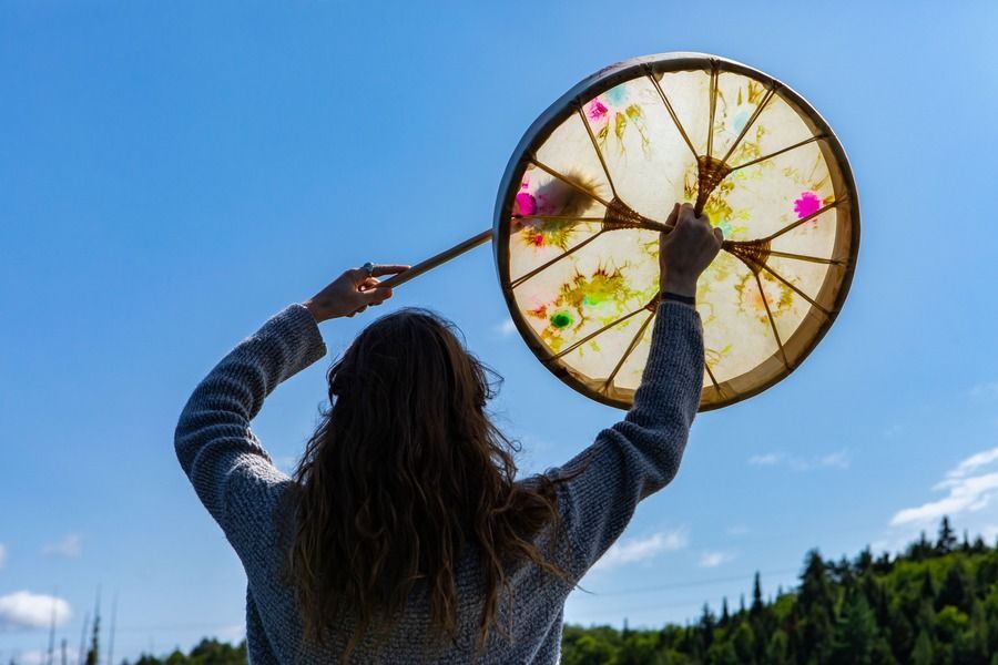 Person holding up a decorated hoop against a blue sky outdoors
