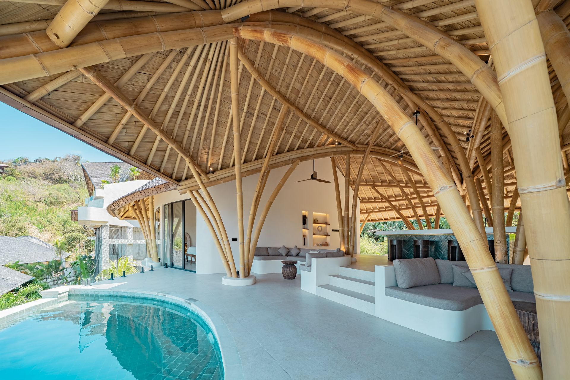 Bamboo structure with a pool, seating area, and outdoor views.