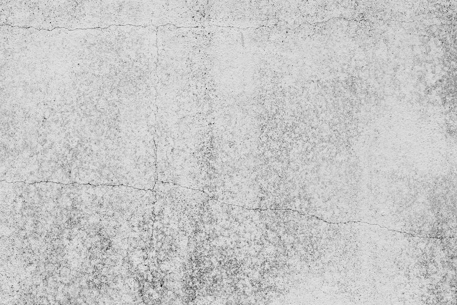 Textured, light gray surface with dark speckles and scratches.