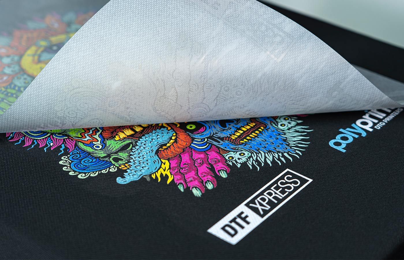 A piece of paper is laying on top of a black shirt with a colorful design on it.