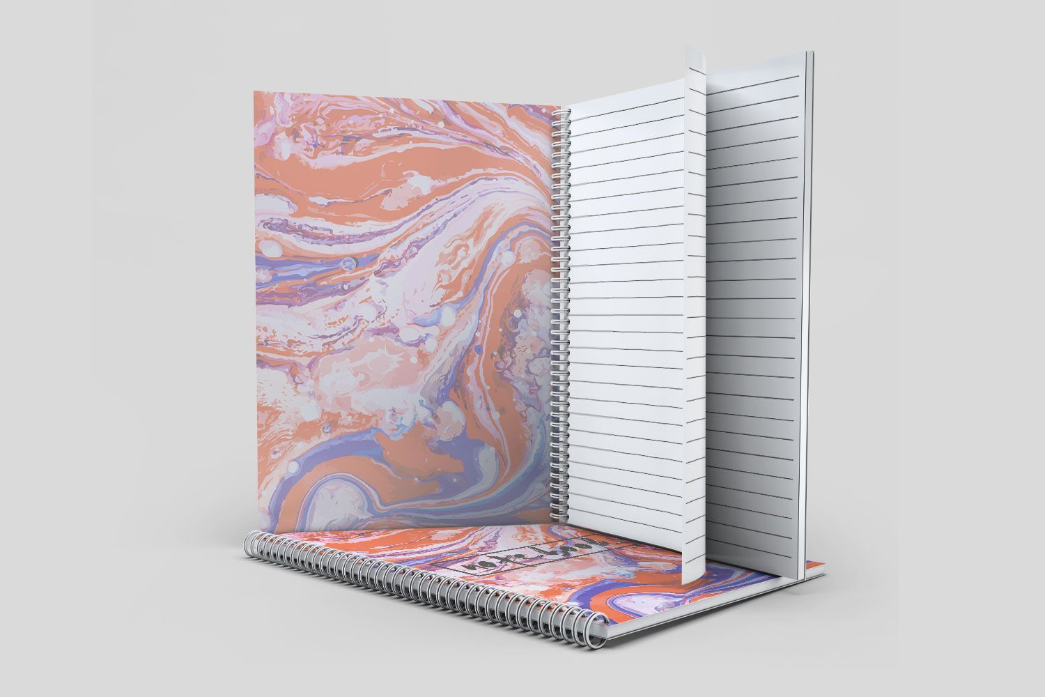A spiral notebook with a marbled cover is sitting on top of each other on a table.
